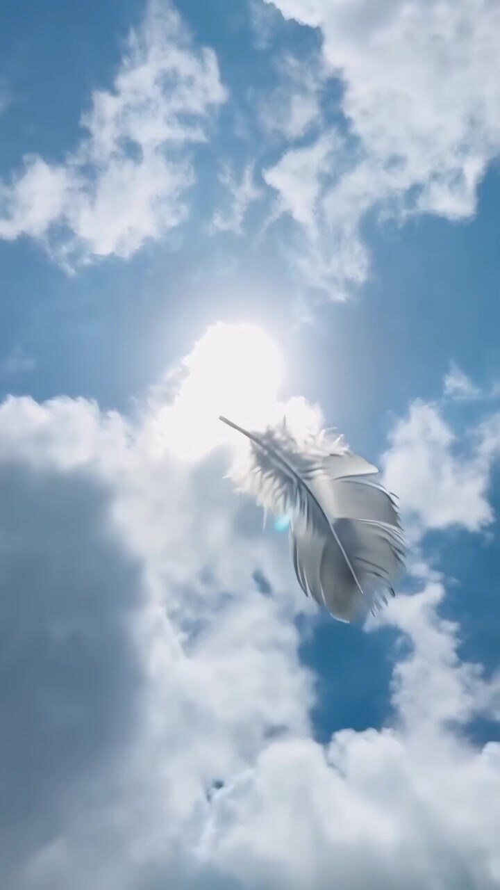 Single White Feather Floating Against a Bright Blue Sky