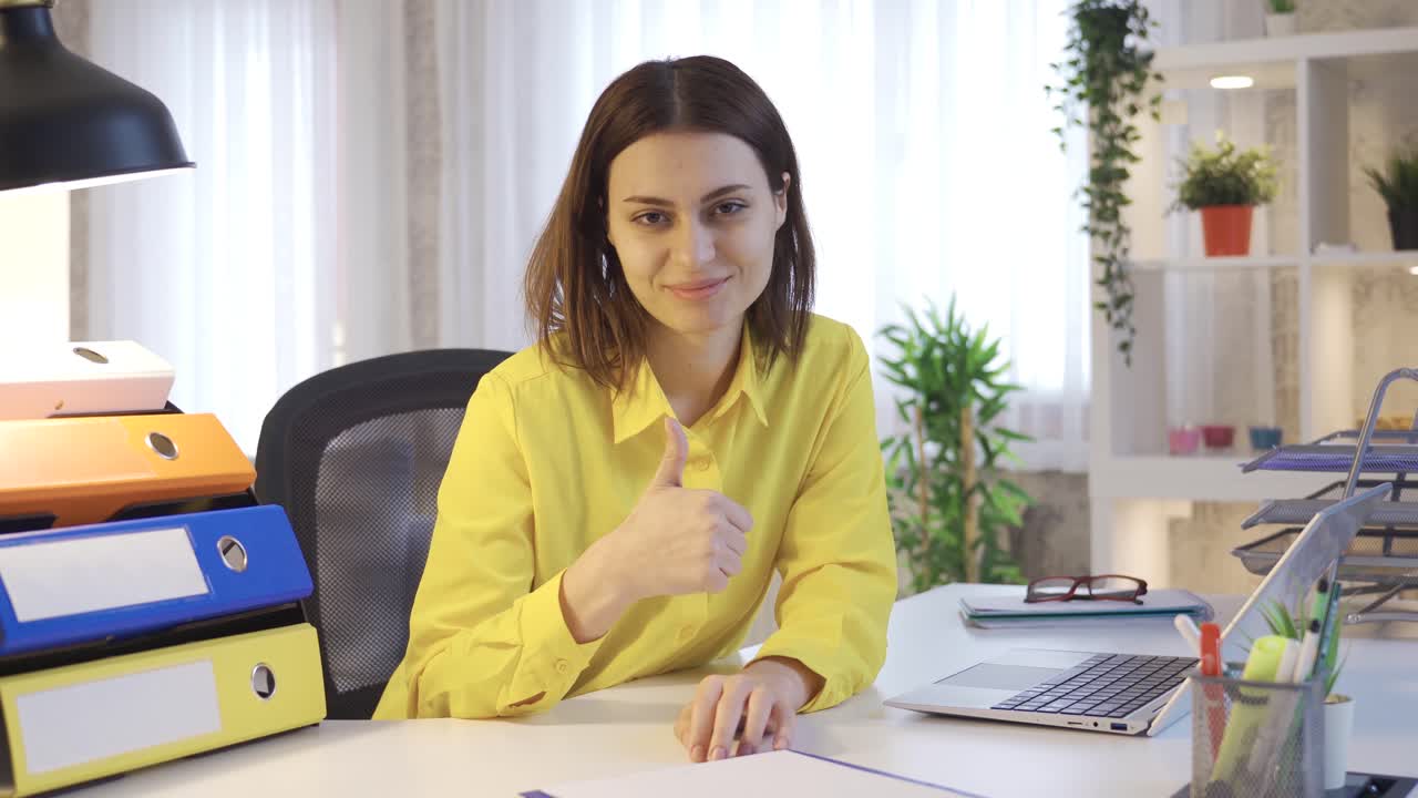 empresaria o mujer de negocios feliz trabajando desde casa y mirando a la cámara apuntando ok.