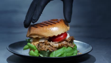 A-burger-with-pulled-meat,-tomato,-egg-and-lettuce-is-completed-by-putting-on-the-bun-top