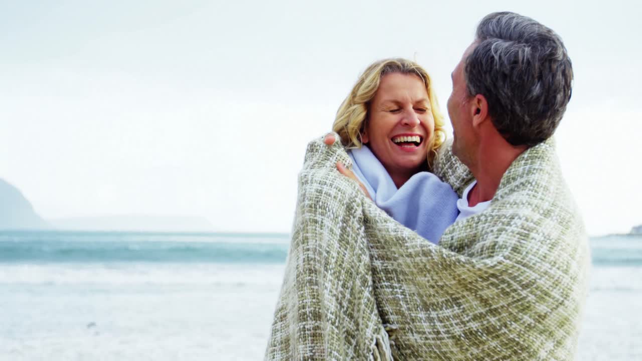 해변 에서 함께 있는 성숙 한 부부