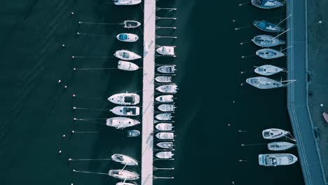 aerial tracking shot looking directly down at jetty with boats moored