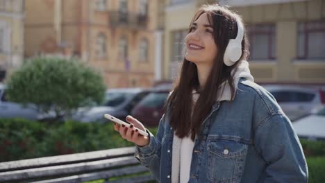 young woman listening to music and walking in the city