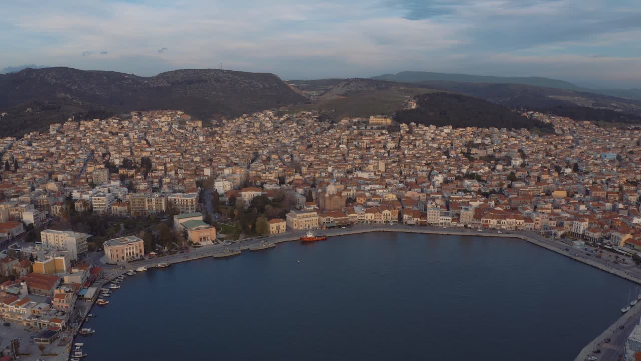 vuelo aéreo de drones sobre el centro de mitilini que revela el amanecer en el mar con ferry a atenas, lesbos, grecia