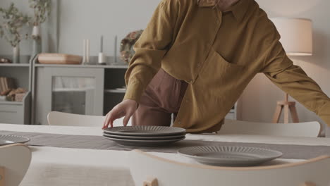 woman arranging plates on table