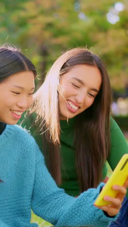 Happy Young Women Sharing a Moment with a Smartphone Outdoors