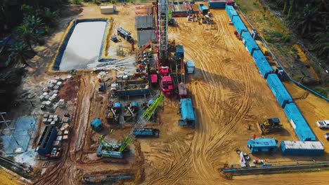 estructura cinematográfica de plataformas de perforación y reacondicionamiento en tierra y equipo de plataformas para la exploración y explotación de petróleo en medio de la jungla rodeada de palmeras durante la puesta de sol