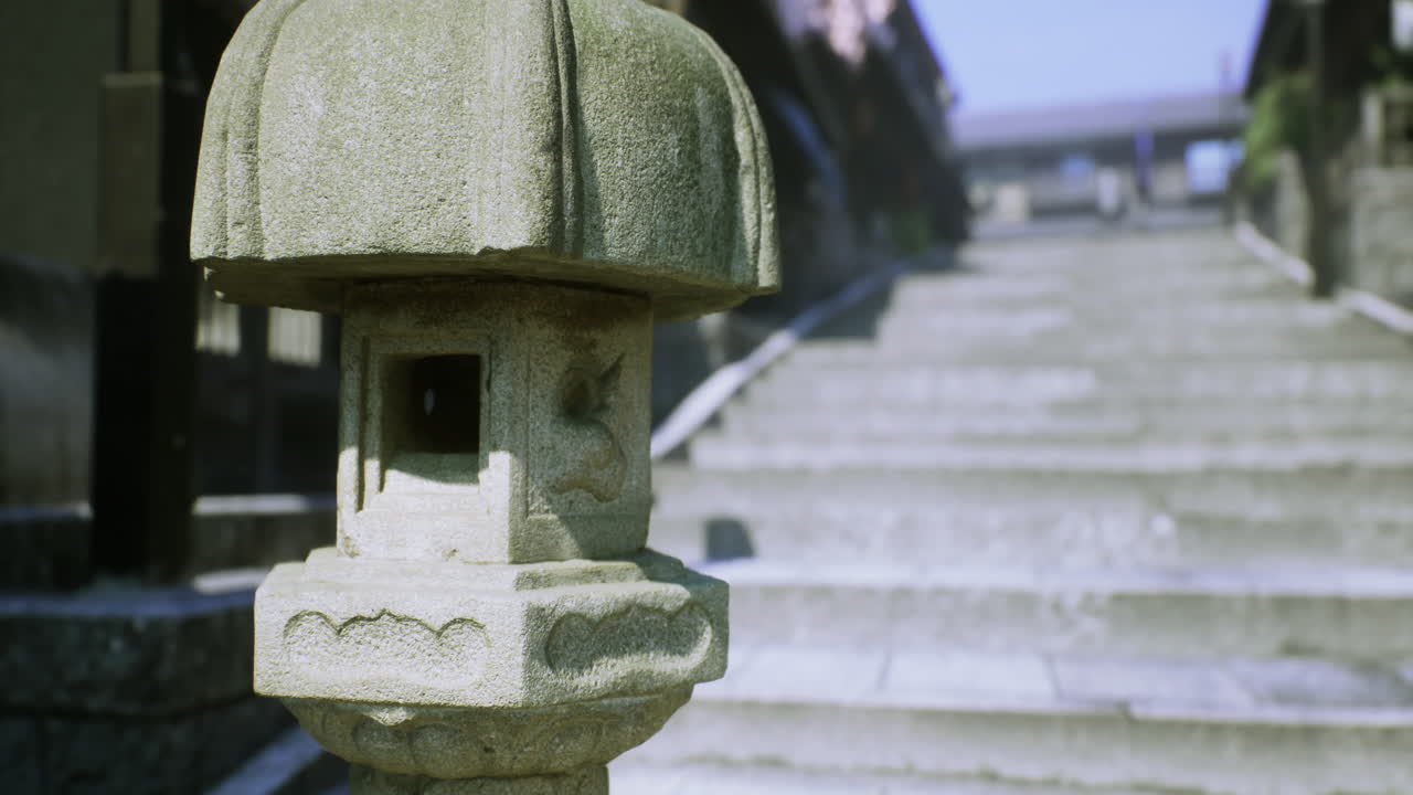 Stone lantern by ancient steps leading to a shrine at sunrise