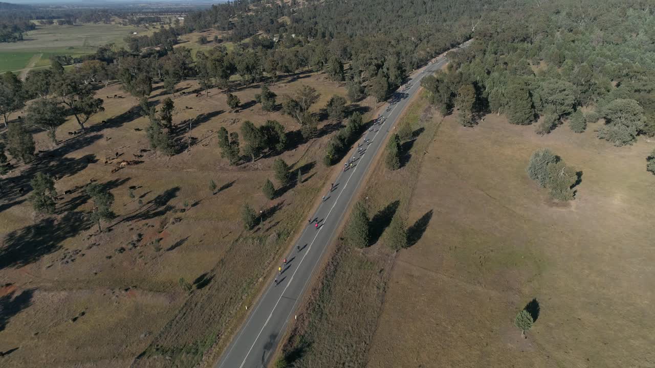 vista aérea de un gran grupo de ciclistas que suben una colina en la popular carrera de engranajes y cervezas celebrada en la ciudad rural de wagga wagga nsw australia rodeada de un hermoso paisaje campestre