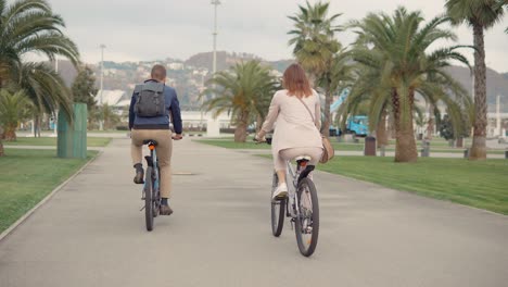 couple cycling in a city park