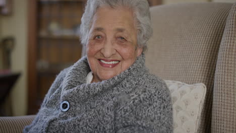 portrait-of-happy-elderly-mixed-race-woman-enjoying-retirement-lifestyle-smiling-cheerful-at-home-sitting-in-living-room