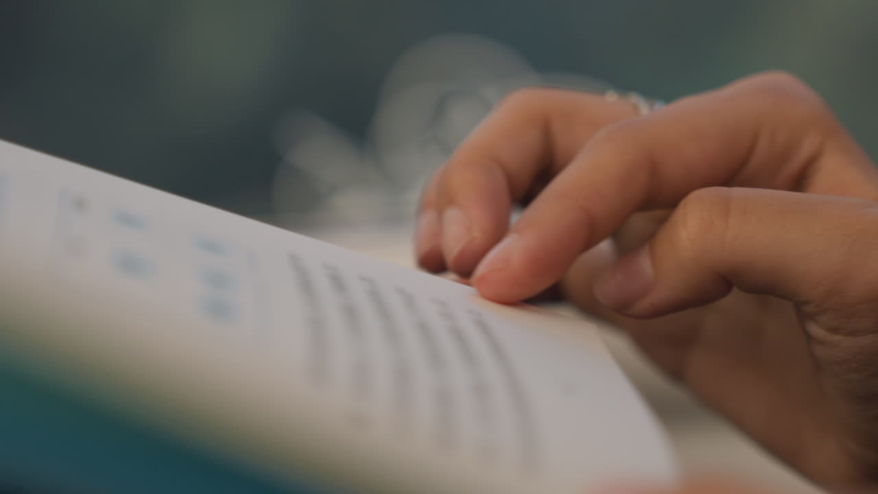 Deliberate fingers turn paper. Quiet scene of hands gently flipping pages by window light. Serene moment where hands delicately turn pages with soft glowing background and calm focus