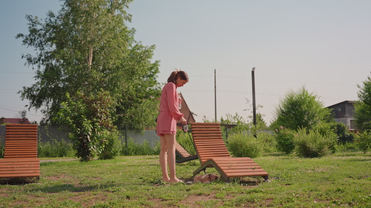 Caucasian Woman Adjusting Lounge Chair Outdoors Slow, Barefoot Steps Across Warm Grass, Wooden Sunbed Setup, Small Dog Nearby, Neighborhood Greenery, Cinematic Warm Tones, Peaceful Domestic Retreat