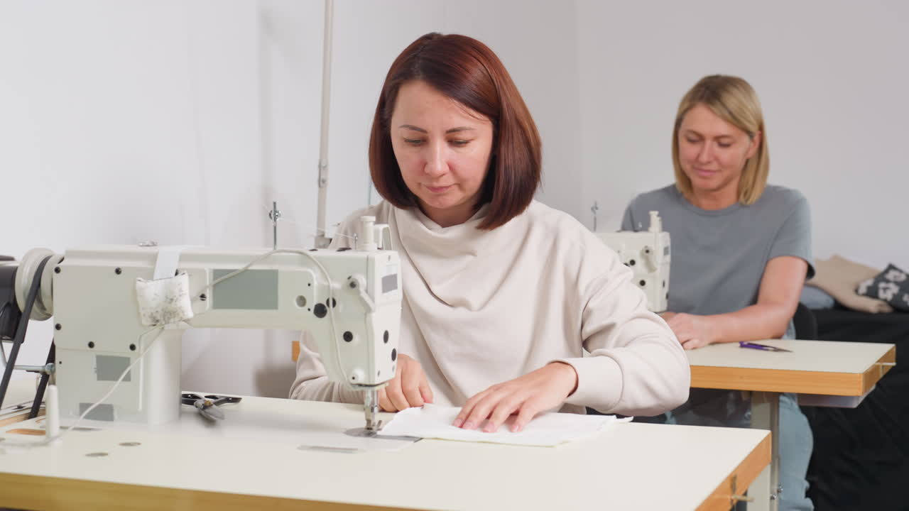 Garment designers sewing garment together, focusing on technique, adjusting fabric, ensuring quality, highlighting creativity, dedication, skillful craftsmanship, synergy in production