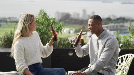 two friends drinking a beer on a rooftop