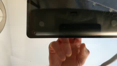 Shot of a telephone from underneath a glass table being picked up and number dialled by a male hand