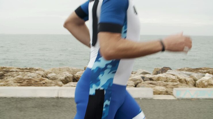 Scatto ravvicinato di atleta uomo che fa jogging lungo il lungomare
