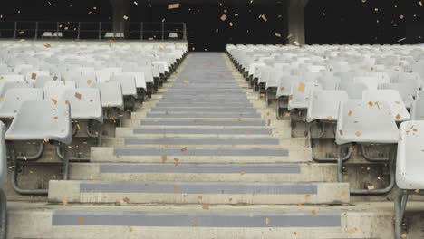 animation of golden confetti falling over an empty rugby stadium digital composition