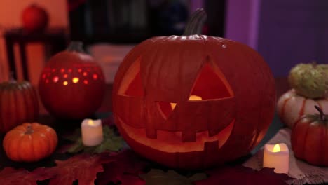 tilt of spooky decoration for halloween with carved pumpkins and candles