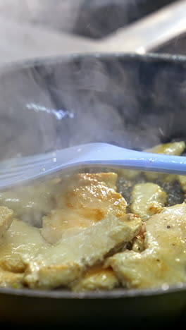 pieces of meat in a frying pan. cooking chicken meat in a hot frying pan. preparation of tasty dish. close-up. vertical video