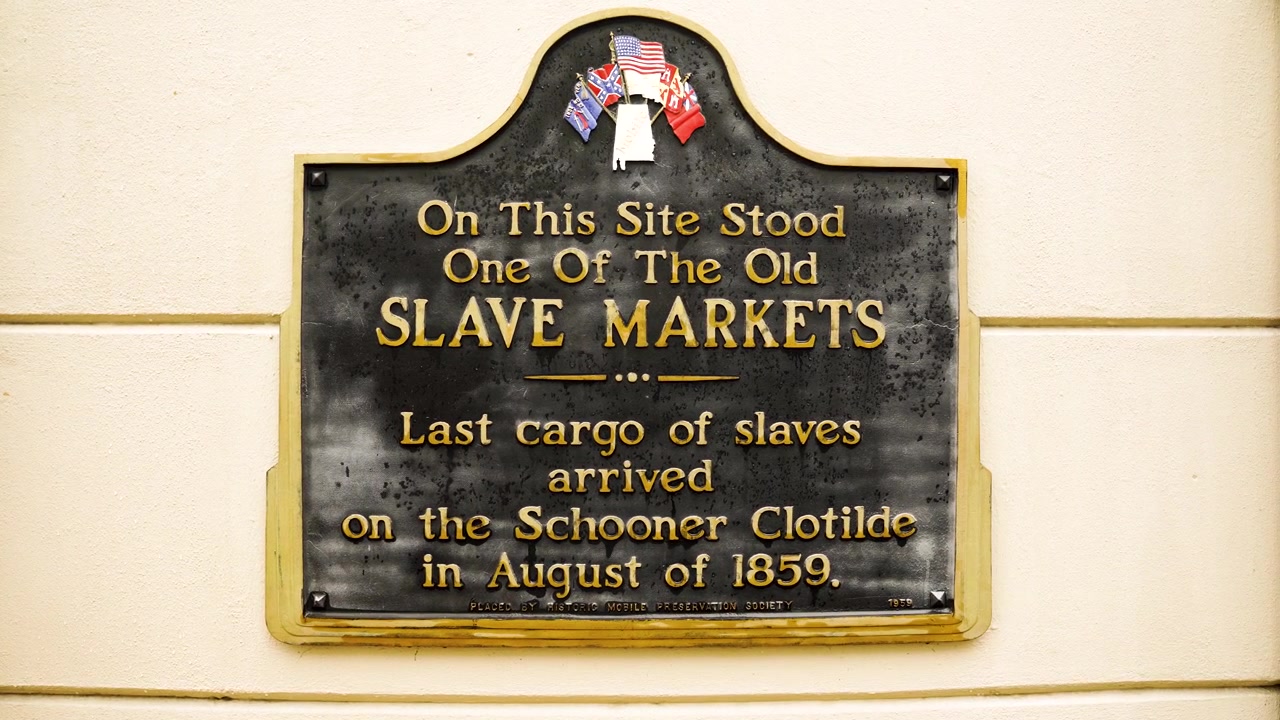 Et stabilt skud fanger en historisk markør i Mobile, Alabama, der henviser til ankomsten af skonnerten Clotilde og den sidst kendte ulovlige slavesending til USA.