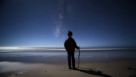 boy stargazing on a secluded beach at night