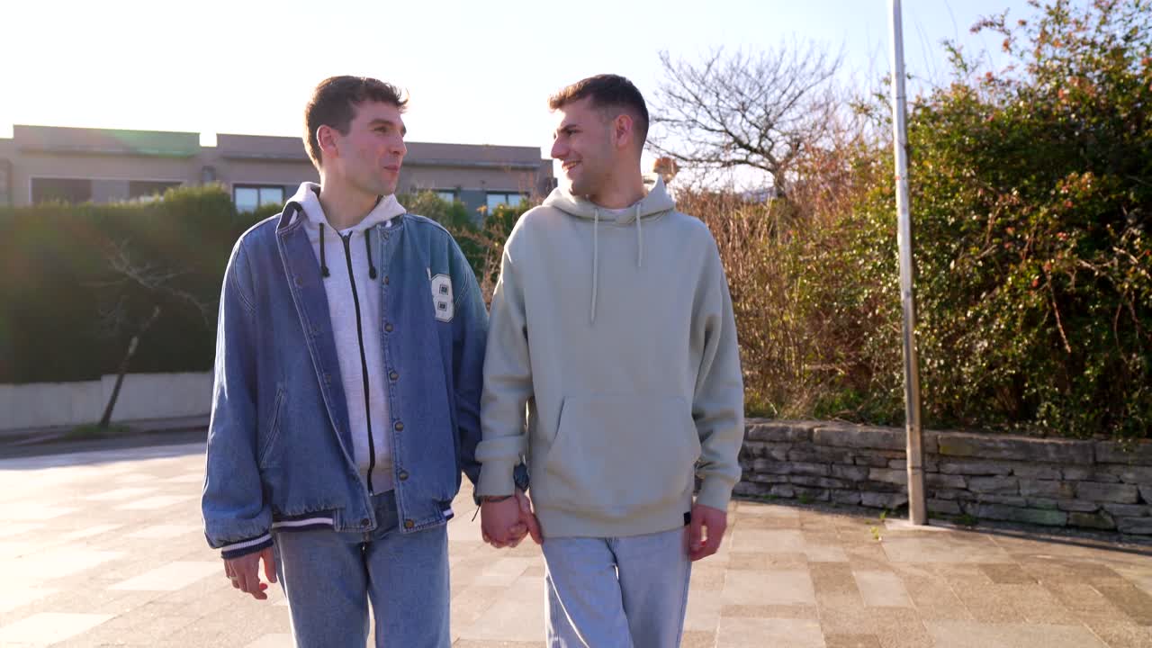Two men walking hand in hand outdoors