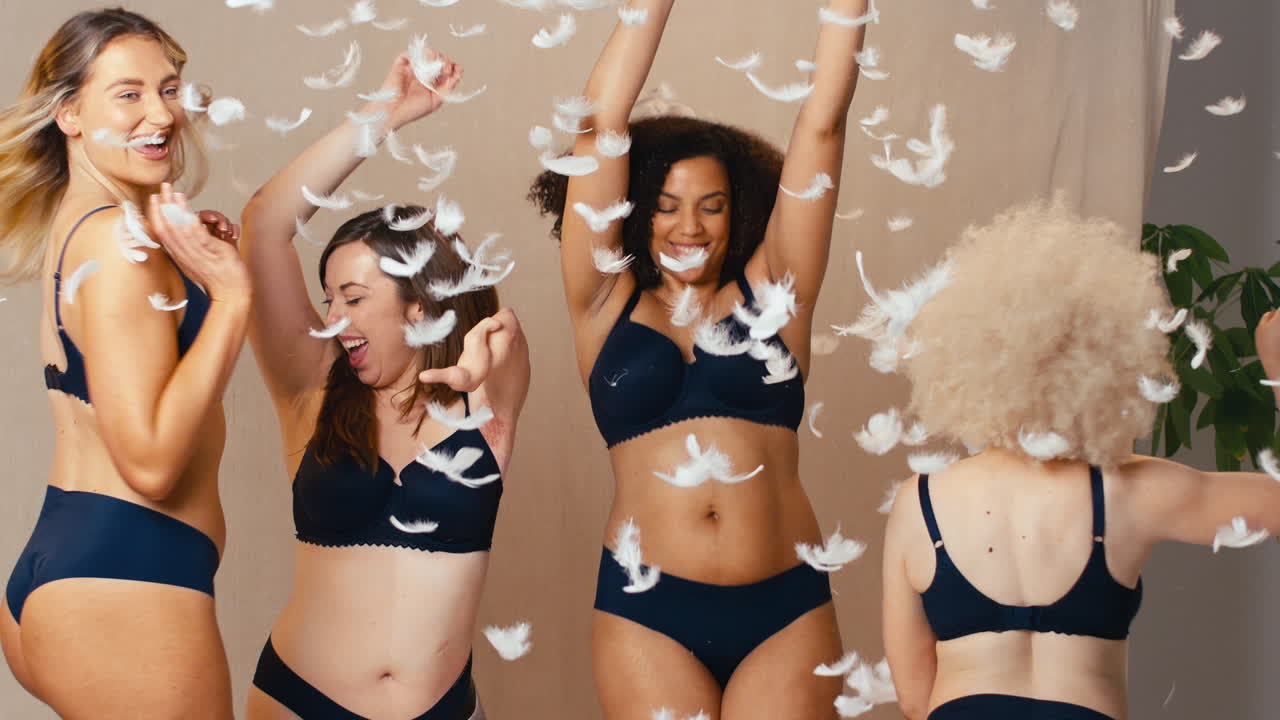 plumas cayendo sobre un grupo de mujeres positivas amigos uno con extremidad protésica en ropa interior