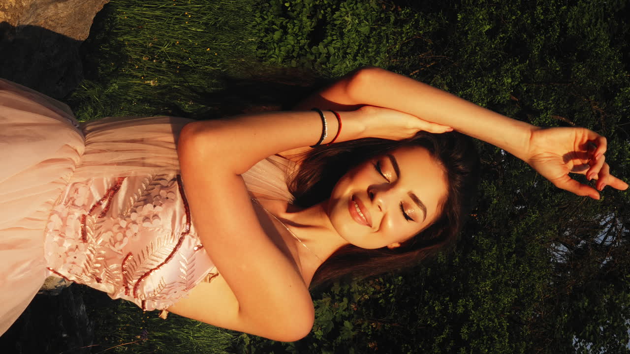 joven hermosa mujer morena, ojos cerrados sonriendo, luz de la hora dorada, fondo del bosque, cámara lenta, vertical