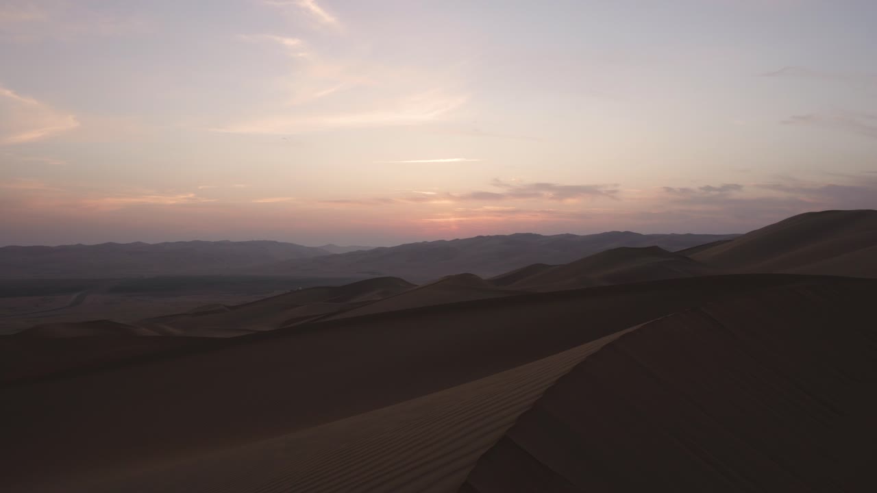 subiendo y bajando por el borde de una duna de arena en el desierto de abu dhabi durante el amanecer