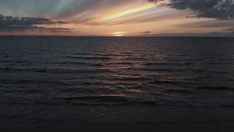 Aerial-view-of-splashing-sea-waves-at-dusk-after-sunset