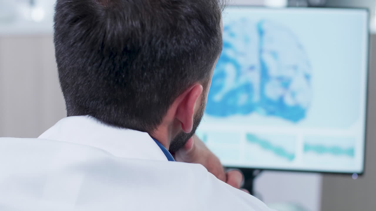 Doctor analyzing brain scan on monitor