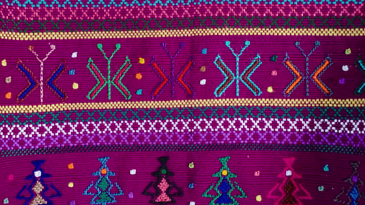 Tessuto tradizionale guatemalteco con figure colorate ricamate e intrecciate