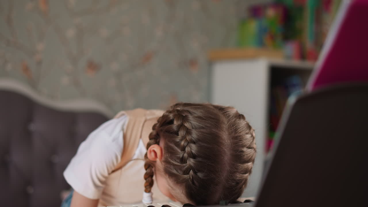 Weary girl pianist rests head on synthesizer keyboard