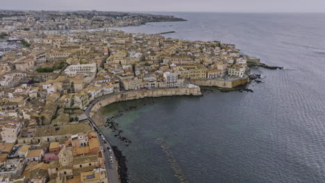 siracusa, italia, sobrevuelo aéreo de drones v5 y alrededor de la isla de ortigia capturando un encantador paisaje urbano costero con edificios históricos de piedra delimitados por el mar mediterráneo - filmado con mavic 3 cine - junio 2023