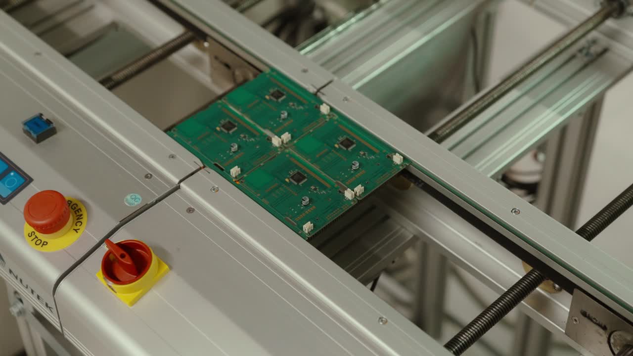 Circuit boards moving on conveyor in factory, captured in slow motion