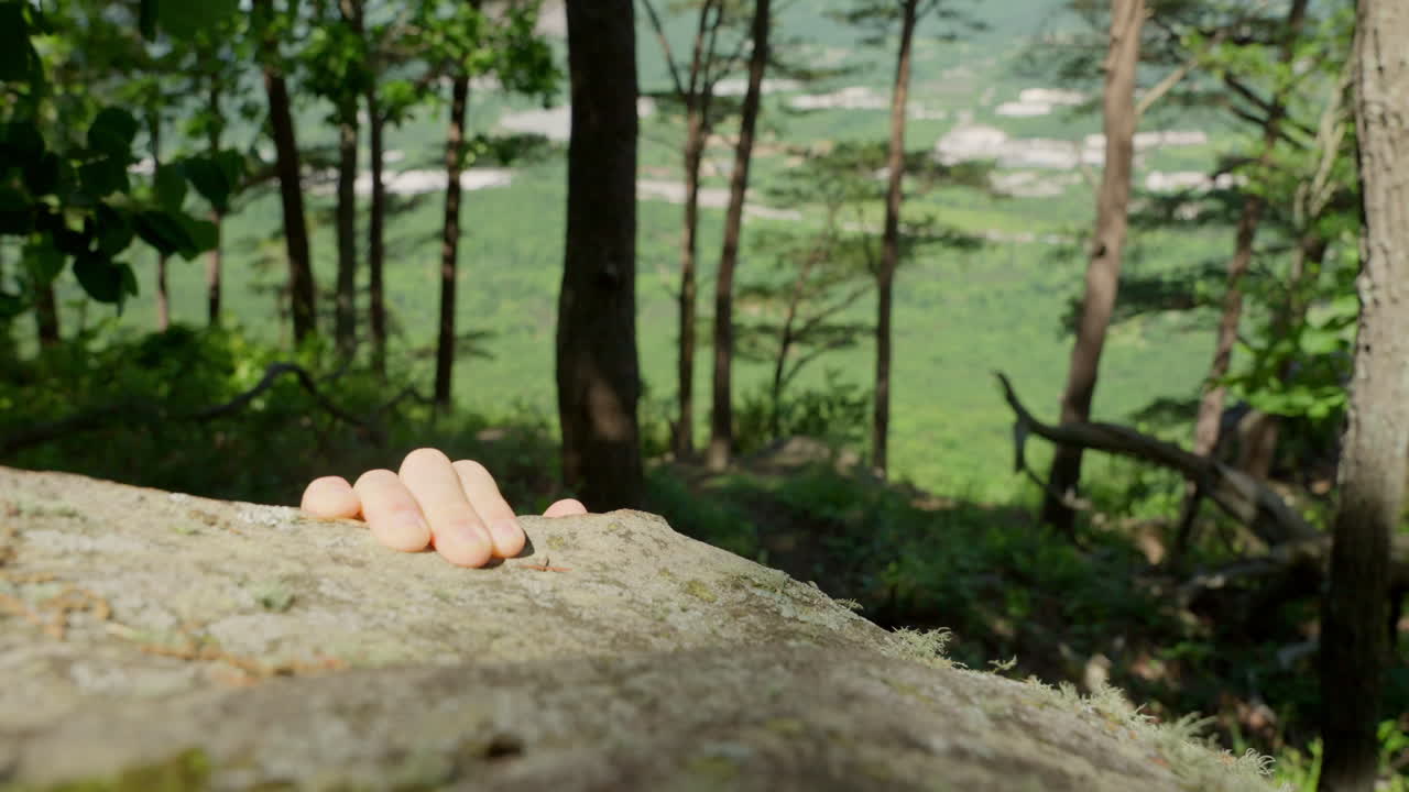 Climbing a cliff in nature. Close-up of determined hands gripping and pulling up a rugged cliff face, capturing the raw intensity and challenge of rock climbing rough surface, striving to reach top.