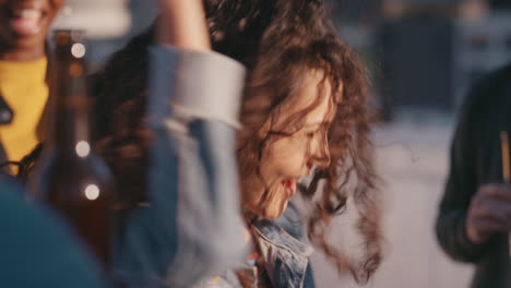 group-of-diverse-friends-hanging-out-beautiful-mixed-race-woman-dancing-enjoying-rooftop-party-at-sunset-drinking-alcohol-having-fun-on-weekend-celebration