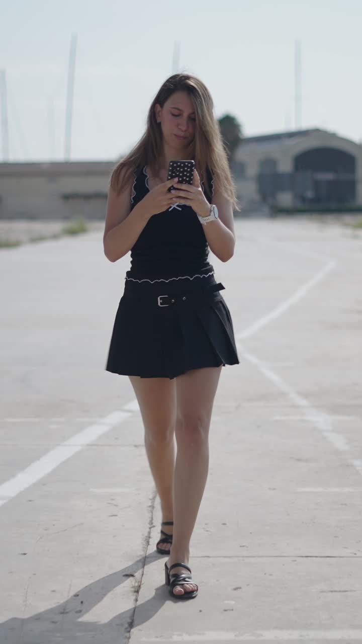 Woman in black skirt walking while using phone