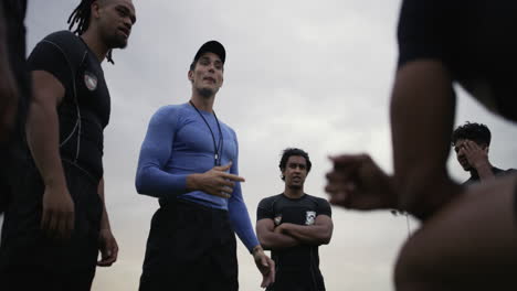 un entrenador hablando con un grupo de jugadores de rugby