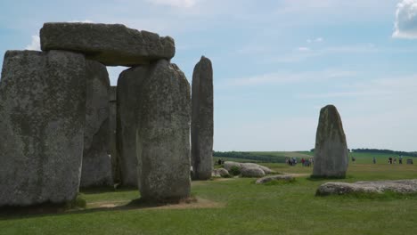 close up view to the stonehenge a prehistoric megalithic structure on salisbury plain in wiltshire england. steady camera, close up on a section of the stonehenge, group of tourists on the background.
