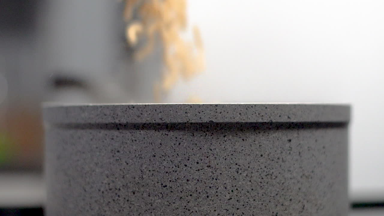 медленная съемка макаронной лапши, насыпанной в кастрюлю с антипригарным покрытием на кухне