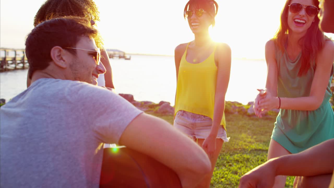 해변에서 춤을 추는 행복한 다민족 사람들이