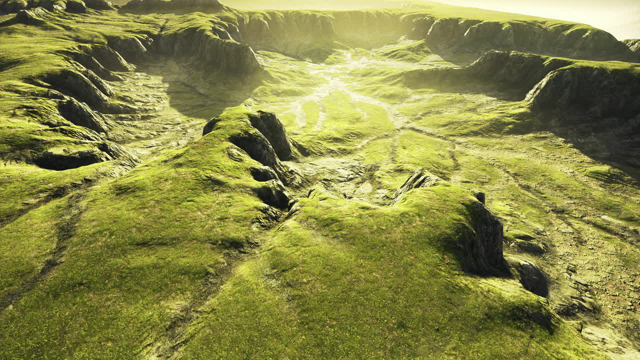 colinas verdes y terreno rocoso bajo la suave luz del sol al amanecer