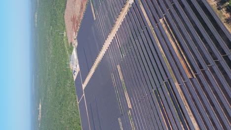 aerial dolly out, large renewable energy park with solar panels, vertical