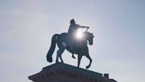 low angle view of sunlight behind statue of danish king frederik, copenhagen