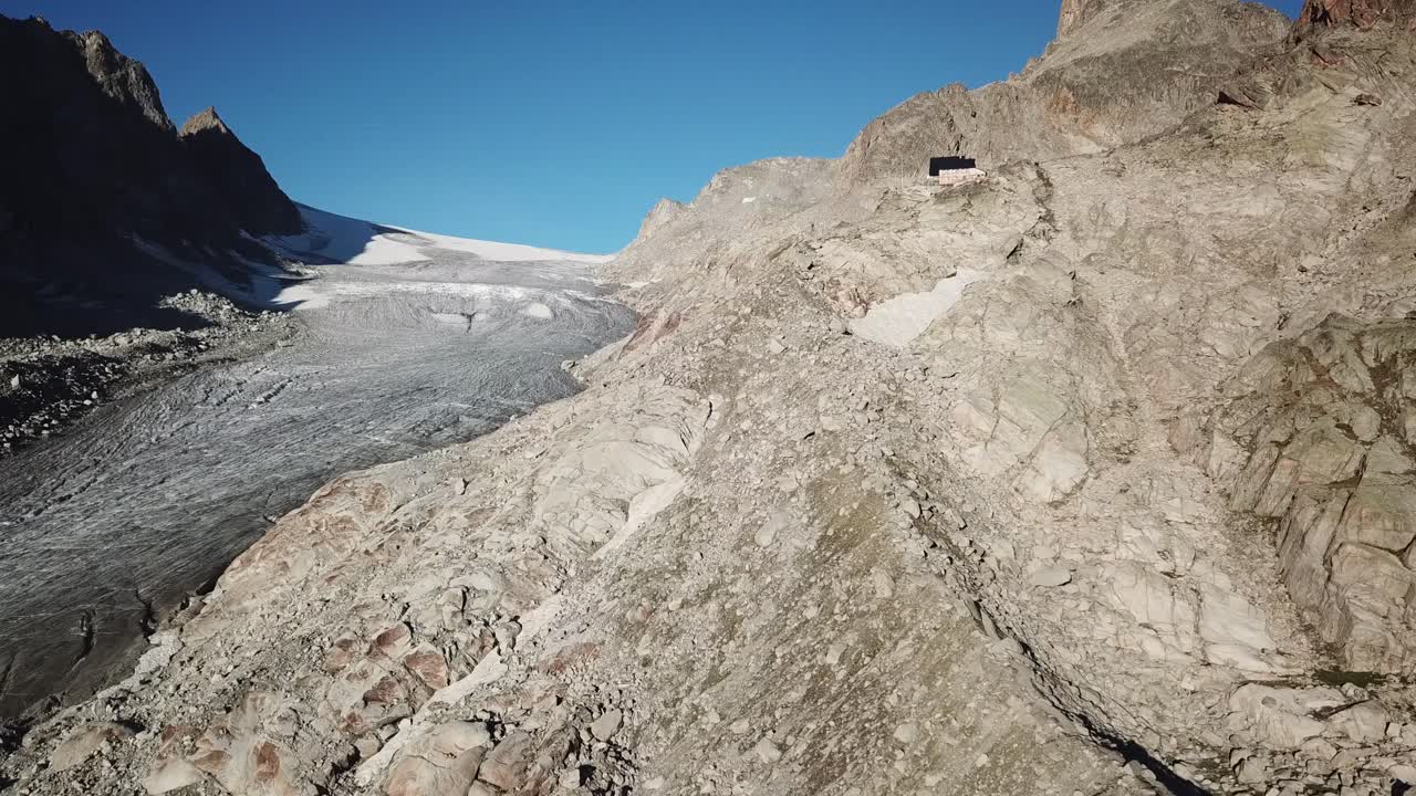 Swiss alps mountains with rocks, glacier, blue sky. Switzerland, aerial drone view