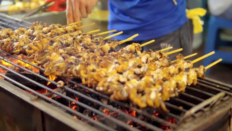 Grilled-Squid-on-a-charcoal-stove-at-Yaowarat-Road-Chinatown,-a-popular-travel-destination-in-Bangkok,-Thailand