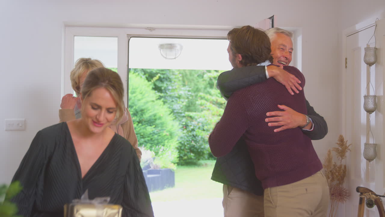 크리스마스 를 축하 하기 위해 선물 을 가지고 도착 하는 노인 부모 들 을 인사 하는 부부