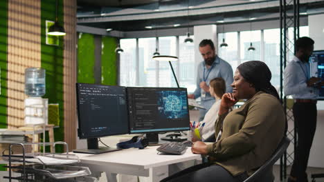 jolly female programmer at office desk pleased after developing application