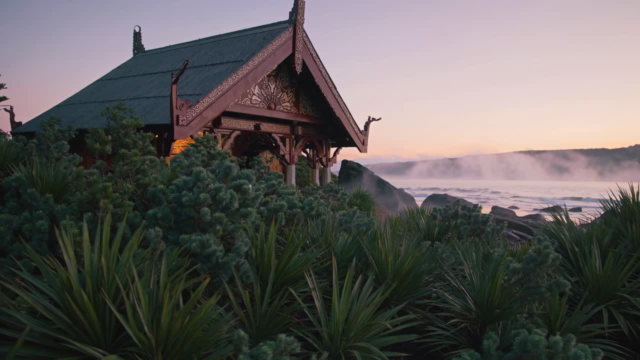A serene coastal scene at sunrise with a traditional wooden structure, captured from a low angle